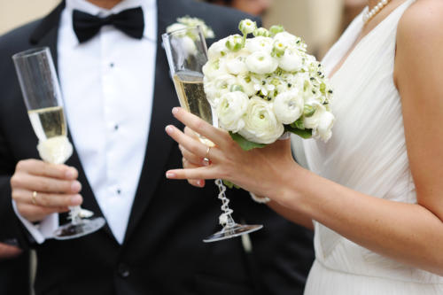 Bride and groom holding champagne glasses