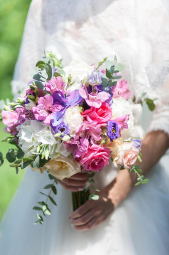 Wedding bouquet of flowers including Red hypericum, Roses, Lilies of the valley, mini Roses, Seeded Eucalyptus, Astilbe, Scabiosa, Pieris, and ivy