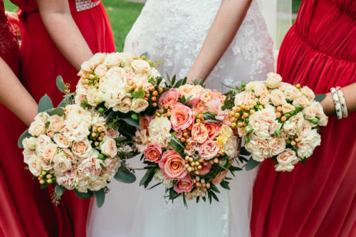 bride in wedding dress and bridesmaids red dressing holding Wedd