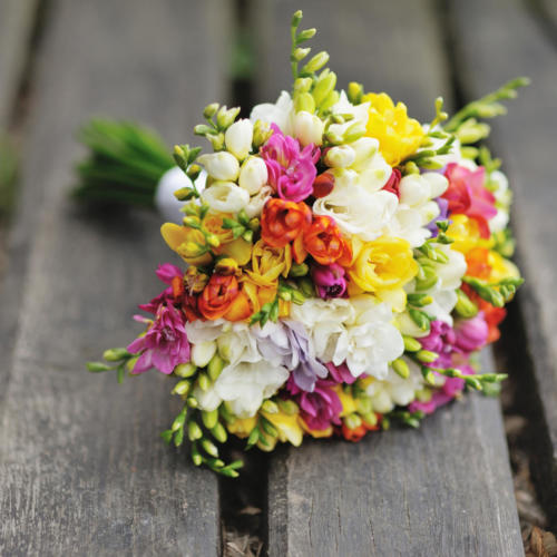 Wedding bouquet on wood surface. Summer wedding.