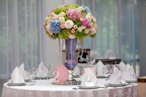 Flowers, wine glasses, napkins and salad on the table for the banquet.