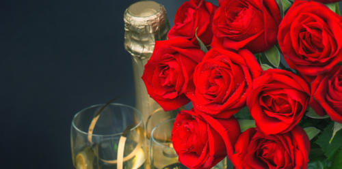 red roses, golden gift box and and champagne on black background