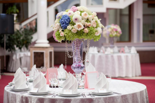 Flowers, wine glasses, napkins on the table for the banquet.